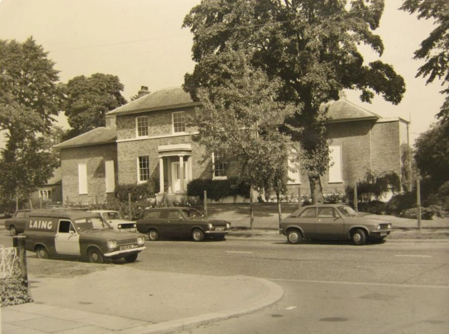 1975 photograph showing the mesh fence and mature deciduous trees at the front